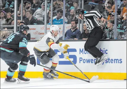  ?? ?? An official jumps out of the way Saturday night as Kraken defenseman Jamie Oleksiak, left, and Golden Knights center Jack Eichel vie for the puck at at Climate Pledge Arena.