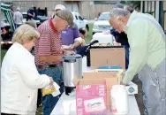  ?? Janelle Jessen/Herald-Leader ?? Less Carroll, right, served food during One Night Without a Home. Those who attended ate a simple meal that included hotdogs and side dishes.