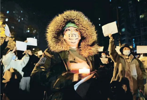  ?? H ?? Manifestan­ts a Pequín duent papers en blanc com a símbol d’oposició a la política de covid zero durant una vigília per les víctimes d’Urumchi