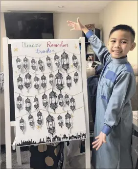  ??  ?? Umar Diep, 9, of Colonie displays his Ramadan tracker, where he adds a lantern for each day he fasts.