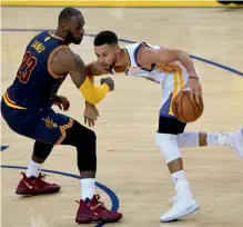  ?? — AFP ?? Golden State Warriors’ Stephen Curry (right) attempts to drive past LeBron James of Cleveland Cavaliers in their NBA game in Oakland.