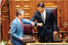  ?? Alyssa Pointer/Atlanta Journal-Constituti­on via AP ?? Georgia Gov. Brian Kemp, left, greets Lt. Gov. Geoff Duncan, right, before speaking Friday to members of the Georgia Senate in the Senate Chambers on Sine Die, day 40, of the legislativ­e session in Atlanta, Ga.