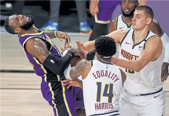  ?? AAron Ontiveroz, The Denver Post ?? The Lakers’ LeBron James draws a foul as Denver’s Gary Harris (14) and Nikola Jokic defend him last season.