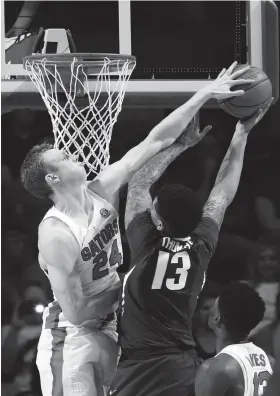  ?? KIM KLEMENT/USA TODAY SPORTS ?? Florida Gators guard Canyon Barry blocks Arkansas forward Dustin Thomas on Wesdnesday night in Gainesvill­e, Fla. Barry celebrated Senior Night by scoring 14 points as the Gators defeated the Razorbacks 78-65.