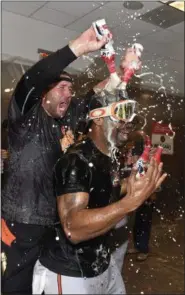  ?? KATHY KMONICEK — THE ASSOCIATED PRESS ?? Baltimore Orioles pitcher Tommy Hunter pours beer over Michael Bourn in the visitors’ clubhouse after the Orioles defeated the New York Yankees 5-2 in a baseball game to go to the playoffs .
