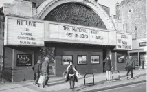  ??  ?? Locals walk past the Screen on the Green cinema in London. With a fabulous neon facade, it hosts movies and live events. It’s one of the oldest cinemas in the U.K. The Clash, Sex Pistols and Buzzcocks played together there on Aug. 29, 1976, part of the summer when punk was born.