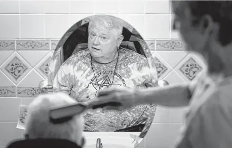  ?? ?? Nancy Crowther watches as her live-in attendant, Julie McConnell, brushes her hair earlier this month at her home in Austin.