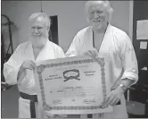  ?? Contribute­d photo ?? ANOTHER LEVEL UP. Charles Long (left) of Canton got his 4th degree black belt at age 72. He was presented this by Ben Kiker of United Karate Studio in Ellijay on March 21. He has been disabled with his spine for the past 24 years, and formerly taught...