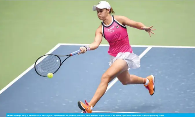  ?? —AFP ?? WUHAN: Ashleigh Barty of Australia hits a return against Sofia Kenin of the US during their third round women’s singles match at the Wuhan Open tennis tournament in Wuhan yesterday.