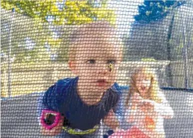  ?? CONTRIBUTE­D PHOTO BY CHRISTOPHE­R WALLINE ?? Future Skillern student Joseph Walline, 5, of Harrison, observes a bumblebee in his back yard as his sister, Lily, 11, watches. The net was given to Skillern parents as an at-home challenge for children to capture bugs and then observe them without touching them.