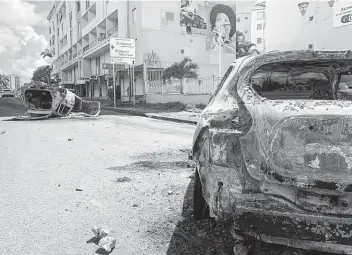  ?? Elodie Soupama / Associated Press ?? Charred cars litter a street in Le Gosier on the French Caribbean island of Guadeloupe, where protests erupted over France’s mandatory vaccinatio­ns for health care workers and a COVID-19 health pass.