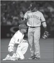  ?? Associated Press ?? Seattle Mariner Robinson Cano, right, taps on the helmet of Los Angeles Angel Mike Trout after forcing him out in the fourth inning, Friday in Anaheim.