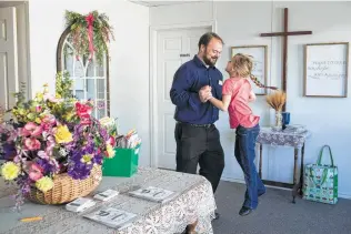  ??  ?? Church remains a large part of life in Sutherland Springs. Five months after the shooting, Evelyn bounces with her dad at the First Baptist Church’s temporary sanctuary.