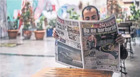  ?? FOTO: AFP ?? Auf ihrer Titelseite schreibt die kemalistis­che Zeitung „Sözcü“: „Was für eine Barbarei“. Auf dem Titelfoto ist ein türkischer Demonstran­t in Rotterdam zu sehen, der von einem niederländ­ischen Polizeihun­d gebissen wird.