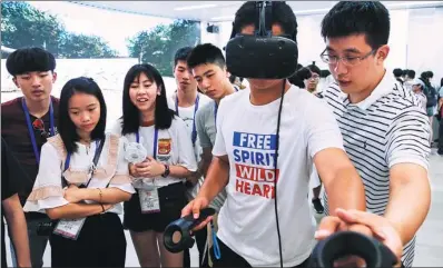  ?? WANG YUAN / CHINA NEWS SERVICE ?? Students from Hong Kong get a taste of virtual reality technology at the Internet Village of Dream Town, an incubation center for internet startups in Hangzhou, Zhejiang province, on Thursday.