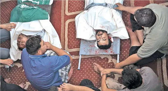  ?? AP ?? Rezos. Los cuerpos de dos primos palestinos, muertos en incidentes separados, rodeados por familiares en su funeral en una mezquita de Gaza./