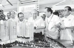  ?? — Gambar Bernama ?? RUANG PAMERAN: Najib (tiga kanan) mendengar penerangan daripada Abdul Mutalib (dua kanan) ketika melawat ruang pameran PR1MA sempena perasmian Ekspo Johor Berkemajua­n 2017 di Dataran Mahkota, Kota Iskandar, semalam.