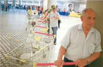  ?? — Reuters ?? Customers line up to get in for shopping at a state-run Bicentenar­io supermarke­t in Caracas.