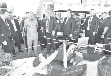  ??  ?? Mahathir (third left) looks on at a model of Russian Helicopter­s as Chechikov (fourth left) gives him a briefing.