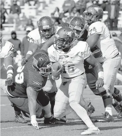  ?? ALGERINA PERNA/BALTIMORE SUN ?? North Carolina Central quarterbac­k Malcolm Bell dodges past Morgan State’s Antoine McCray. Bell left the game after suffering an apparent head injury after being hit hard by Darius Johnson. Morgan State also lost quarterbac­k Chris Andrews in the third...