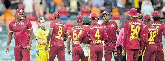  ?? CWI PHOTO ?? West Indies players congratula­te Australian batsmen, Steve Smith (second left) and Josh Inglis (partially hidden) during a One-Day Internatio­nal game between the teams at the Manuka Oval in Cranberra Australia yesterday.