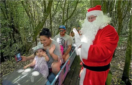  ?? PHOTO: MURRAY WILSON/ FAIRFAX NZ ?? Santa waves to children on the train.