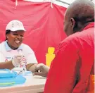  ?? Picture: FREDLIN ADRIAAN ?? CHECKING UP: Nompumelel­o Luthuli conducts an HIV test for a resident