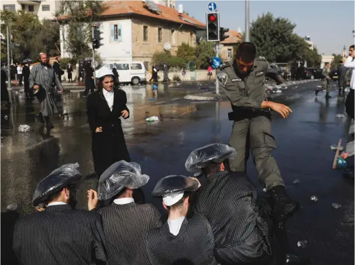  ?? (Reuters) ?? ULTRA-ORTHODOX MEN and police clash during a protest against serving in the Israeli army.