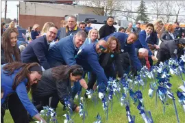  ?? PHOTO BY KAITY ANDREY — MISSION KIDS ?? Dignitarie­s plant pinwheels in a ceremony at Norristown Transporta­tion Center.