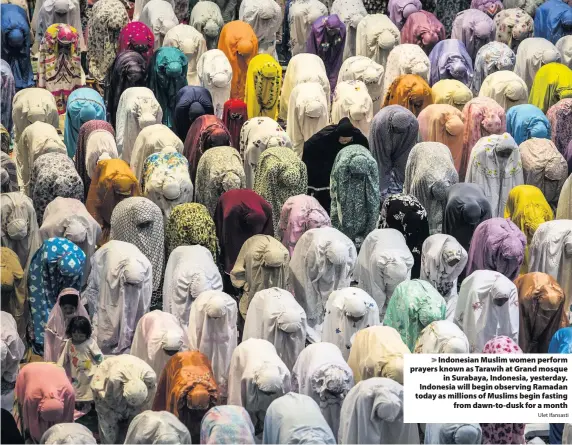  ?? Ulet Ifansasti ?? > Indonesian Muslim women perform prayers known as Tarawih at Grand mosque in Surabaya, Indonesia, yesterday. Indonesia will begin observing Ramadan today as millions of Muslims begin fasting from dawn-to-dusk for a month