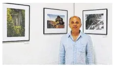  ??  ?? Gilles Bucaille devant quelques-unes des photos de l’exposition « Tronches et trognes ».
