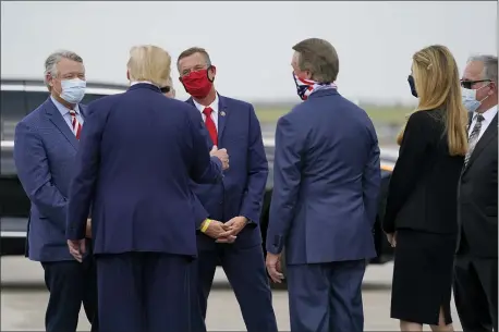  ?? EVAN VUCCI — THE ASSOCIATED PRESS ?? Rep. Doug Collins, R-Ga., in red face mask, talks with President Donald as he arrives at Hartsfield-Jackson Internatio­nal Airport, Wednesday, July 15, 2020, in Atlanta. Sen. Kelly Loeffler, R-Ga., second from right, and Sen. David Perdue, R-Ga., third from right, listen.