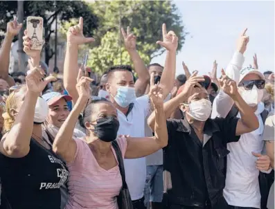  ?? ELIANA APONTE/AP ?? Anti-government demonstrat­ors march Sunday in Havana. Hundreds of protesters took to the streets in several cities in Cuba to protest against ongoing food shortages and high prices of foodstuffs.