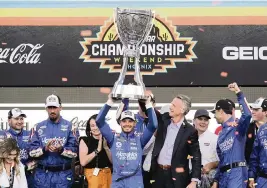  ?? RICK SCUTERI AP ?? Kyle Larson celebrates after winning his first NASCAR Cup Series championsh­ip for Hendrick Motorsport­s on Sunday at Phoenix Raceway. It’s the 14th title for Hendricks.