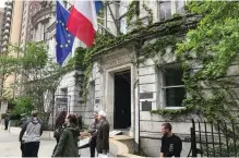  ?? (Arnaud Sebbane) ?? PEOPLE WAIT as others walk outside the French Consulate in New York on Saturday afternoon.