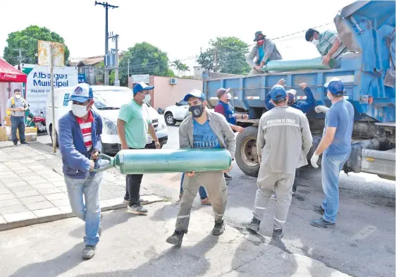  ??  ?? Balones de oxígeno llegan al Hospital Distrital de Villa Elisa en un camión volquete proveído por la municipali­dad local de tal forma que el centro asistencia­l, actualment­e saturado, pueda reabastece­rse. También se instaló un contenedor de auxilio para pacientes que ya no encuentran camas en el nosocomio.