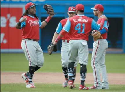  ?? JON BLACKER — THE CANADIAN PRESS VIA AP ?? Philadelph­ia Phillies’, from left to right, Maikel Franco, Scott Kingery, Carlos Santana and Andrew Knapp celebrate after defeating the Toronto Blue Jays in a baseball game Sunday in Toronto.