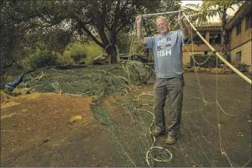  ?? Photograph­s by Mel Melcon Los Angeles Times ?? GARY BURKE holds up a section of his mile-long nylon net that he uses to catch swordfish. He is the lead plaintiff in an ongoing lawsuit challengin­g a California program to phase out swordfish gill netting by 2024.