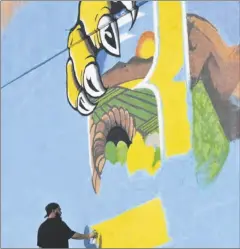  ?? PHOTO TOM BODUS ?? Artist Jesus Lopez works on the “Greetings from Brawley” mural Friday.
