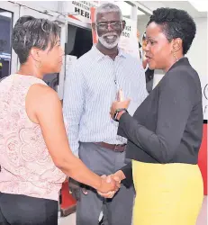  ??  ?? Greetings are in order between Ayana Jones (left), chief financial officer at the Ministry of Justice, and Mariame McIntosh-Robinson, president and CEO at First Global Bank, during the launch of its First Global Money Link agent bank inside Stapharm Services, located at the Boulevard Supercentr­e in Kingston recently. Looking on is Clinton Brissette, agent owner.