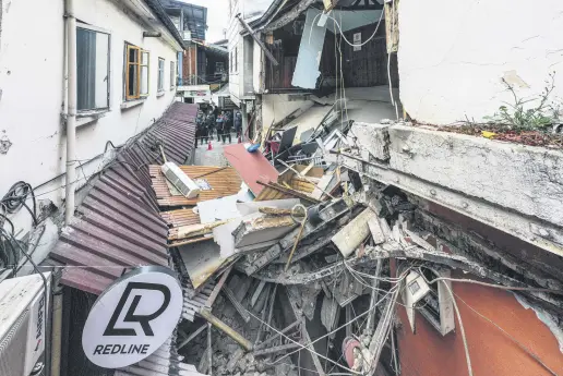  ?? EDITOR YUSUF ZİYA DURMUŞ ?? Pieces of damaged houses litter a narrow street, in Düzce, northern Türkiye, Nov. 23, 2022.