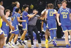  ?? Jamie Squire Getty Images ?? UCLA PLAYERS and coaches exult after the Bruins beat top-seeded Michigan to advance to the Final Four. Next up is top-ranked and undefeated Gonzaga.