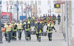  ?? AFP ?? Police and paramedics on Christmas Day on the otherwise empty streets of Augsburg in southern Germany.