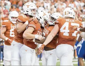  ?? RICARDO B. BRAZZIELL / AMERICAN-STATESMAN ?? Texas players celebrate a touchdown Saturday during UT’s 28-21 victory over Tulsa. Both athletic director Chris Del Conte and head coach Tom Herman say that the Longhorns are showing signs of improvemen­t.