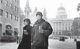  ?? RICH PEDRONCELL­I/AP ?? Mattelin Bautista and Stephen Penner wear masks to deal with smoke from the Camp Fire.