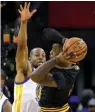  ?? Associated Press ?? Cleveland Cavaliers’ LeBron James, right, is defended by Golden State Warriors’ Andre Iguodala during the first half Monday in Oakland, Calif.