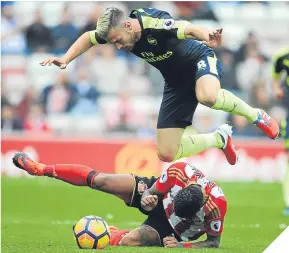  ??  ?? Aaron Ramsey of Arsenal comes off best as he is challenged by Sunderland’s Javier Manquillo.