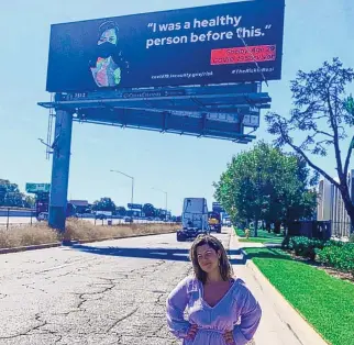  ?? GUSTAVO SOSA/KFF HEALTH NEWS/TNS ?? Shelby Hedgecock stands in front of a billboard from a Los Angeles County public health campaign that features her as a long COVID patient.