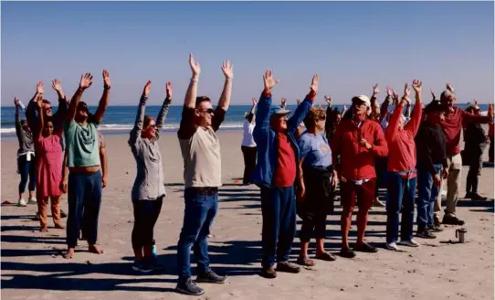  ?? CROWD PHOTOS BY JESSICA RINALDI/GLOBE STAFF ?? As people raised their hands as they stood on Nantasket Beach to spell out the words HULL FOR ALL last Sunday . . .