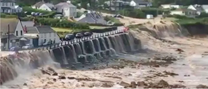  ??  ?? Inundated: Floodwater pours on to the beach from the village of Coverack on the Lizard Peninsula yesterday and, below, emergency services work at the scene